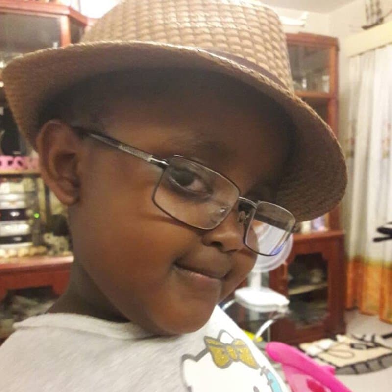 Joy as a little girl in a hat and glasses